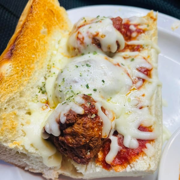 Figaretti's meatball sub with melted mozzarella cheese, marinara sauce, and parsley on toasted bread.